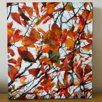 Small abstract painting of autumn leaves by UK artist Julia Brown with vibrant orange, red, and teal colours on a white background.