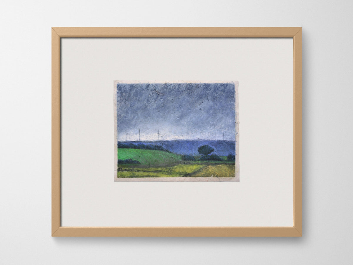 a framed artwork of fields on a white wall