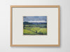 a framed artwork of fields on a white wall
