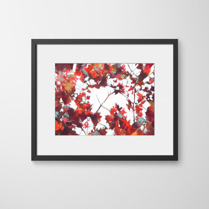 An abstract textured print showing glimpses of bright light through branches with red, crimson and and teal maple leaves, in a black wood frame, by Julia Brown